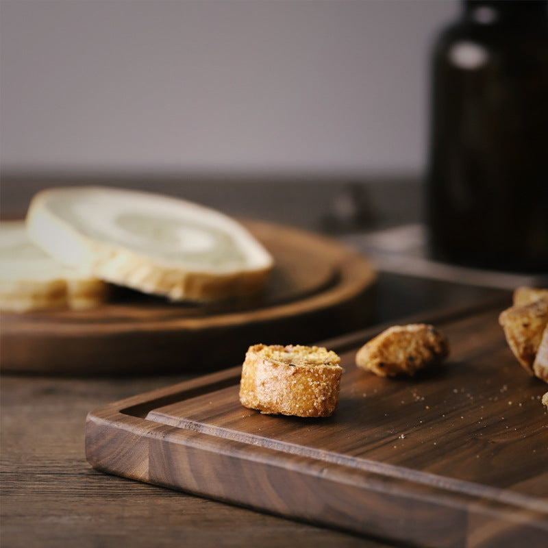 Wooden cutting board with crackers on a wooden surface