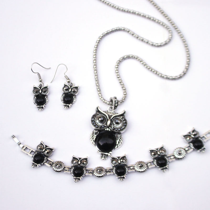 Black Vintage Turquoise Owl Jewelry Set Necklace Earrings Bracelet on a table