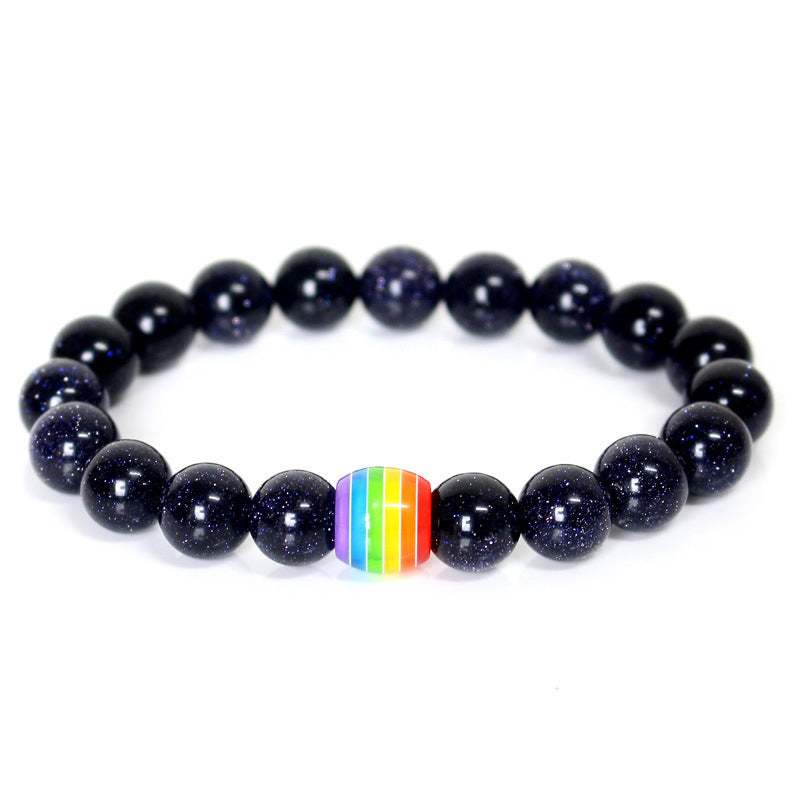 Black beaded bracelet with a rainbow charm on a white background