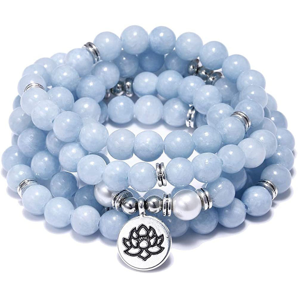 Stack of light blue beaded bracelets with a silver lotus charm on a white background