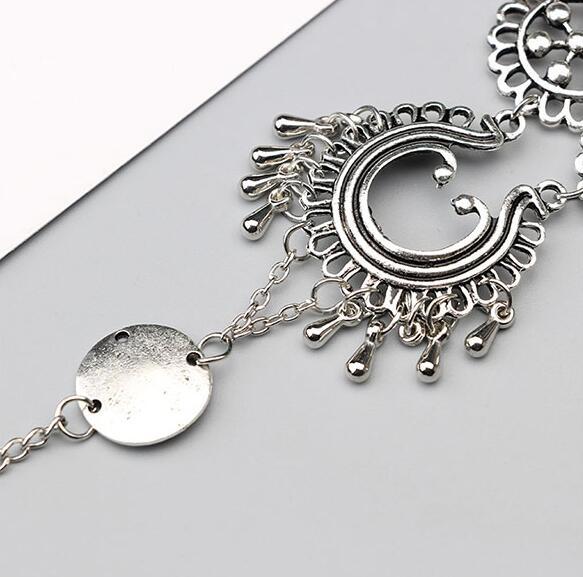 Silver bracelet with intricate designs on a light gray background