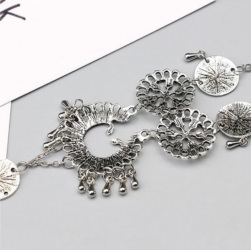 Silver bracelet with intricate designs on a light gray background