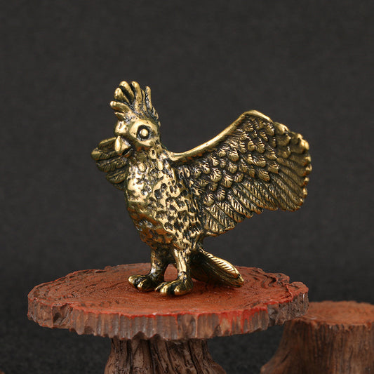 Brass parrot figurine on a textured red base against a dark background