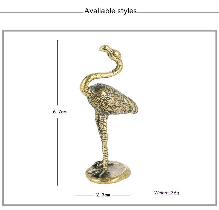 Gold flamingo figurine with measurements on a white background
