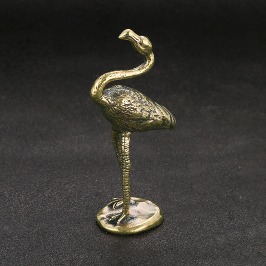 Bronze flamingo figurine on a dark background