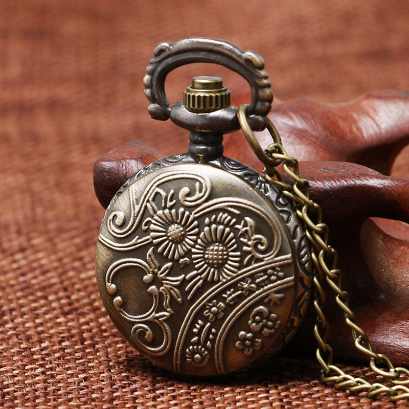 Bronze pocket watch with intricate designs on a brown textured background