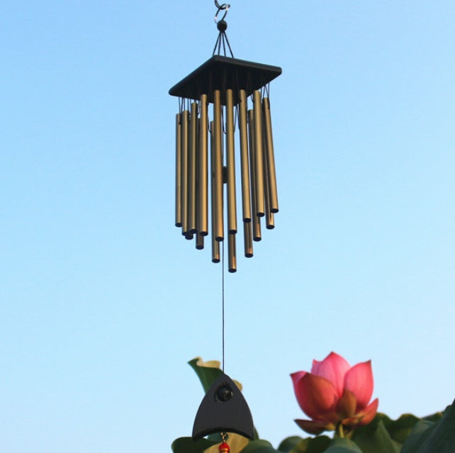 Decorative wind chime with a bird and flower against a clear blue sky