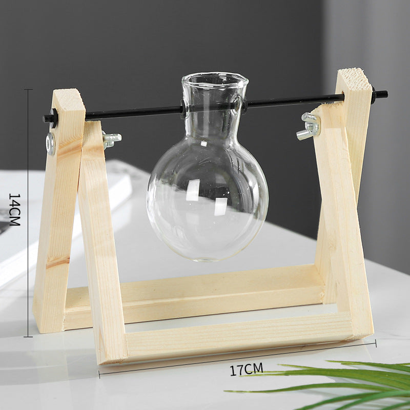Clear glass vase on a wooden stand with measurements indicated