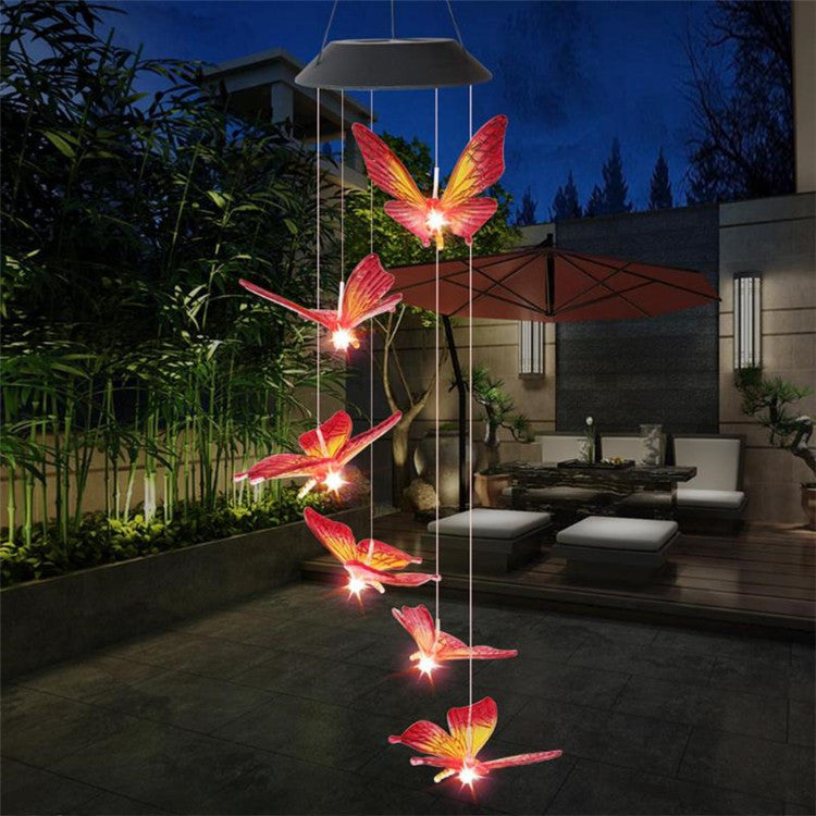 Butterfly-shaped solar lights hanging in a garden at night