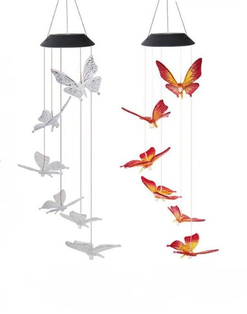 Butterfly-shaped wind chimes with solar panels on a white background