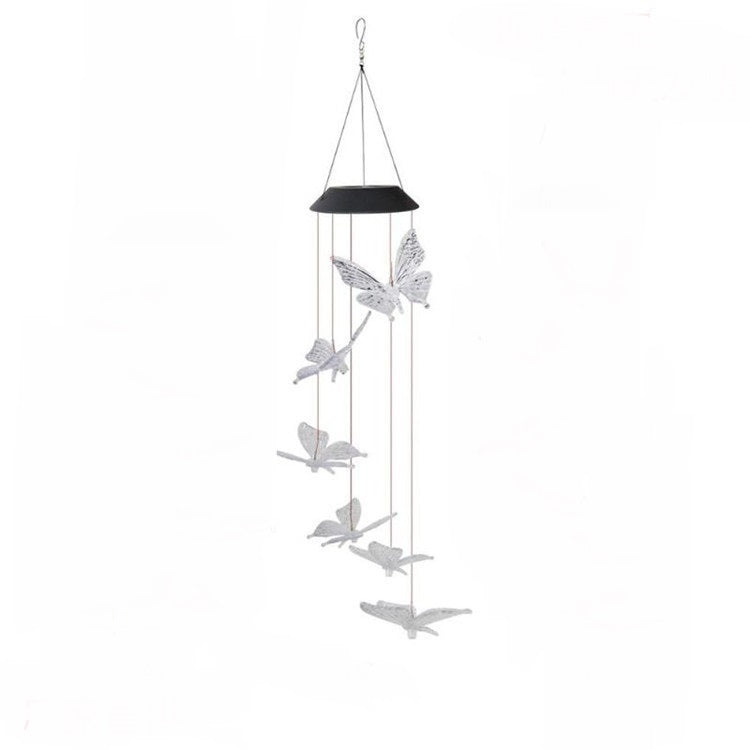 Butterfly-shaped wind chime hanging against a white background