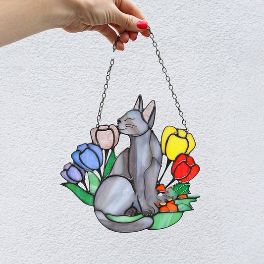 Decorative stained glass panel with a cat and flowers held by a hand on a light gray background