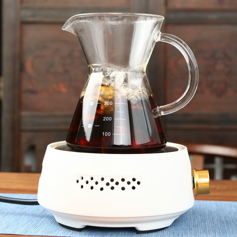 Glass coffee maker with a white base on a wooden table