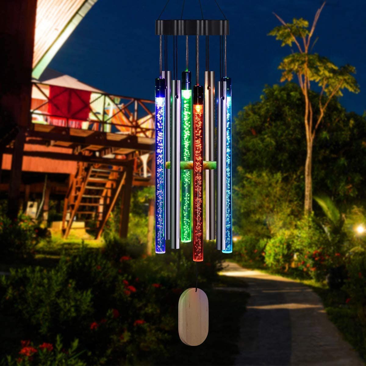 Colorful LED wind chime in a garden setting with a house in the background
