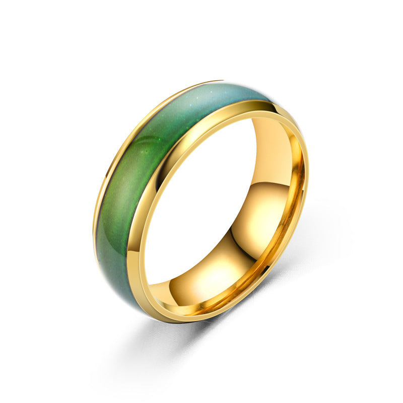 Gold ring with green ceramic inlay on a white background
