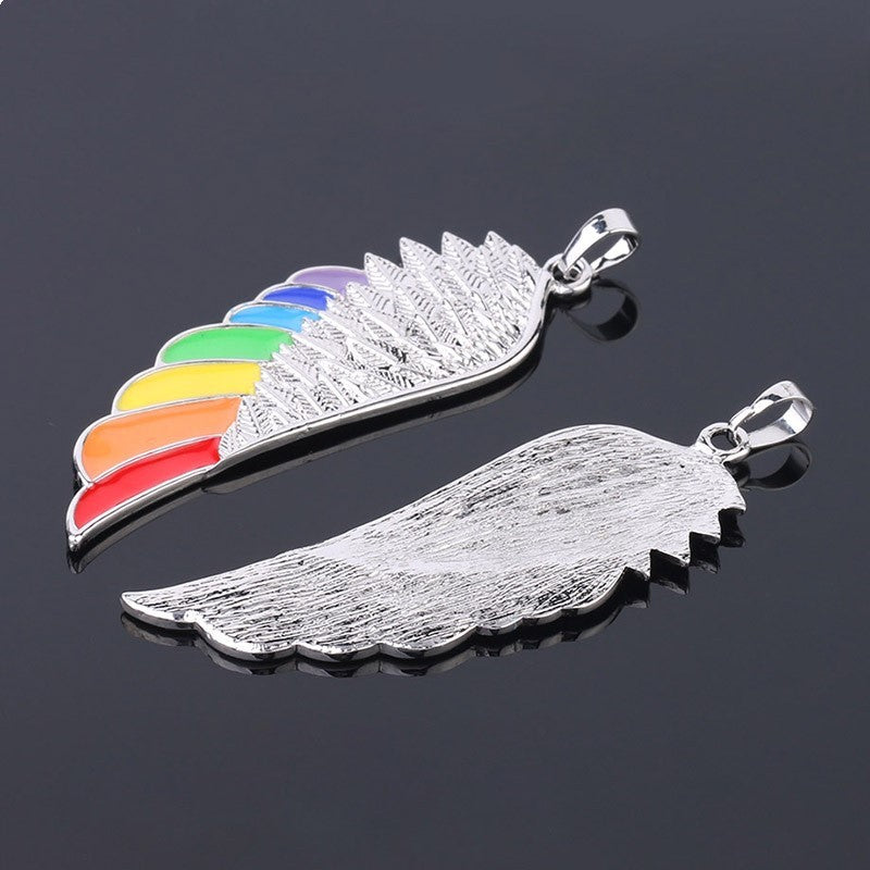 Silver angel wing pendant with rainbow design on a black background