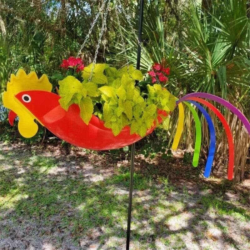 Colorful bird-shaped flower holder with flowers hanging in a garden setting