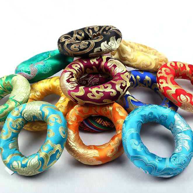 Colorful decorative sound bowl rings with intricate patterns on a white background