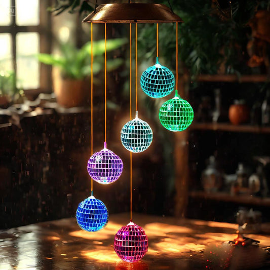 Colorful disco ball wind chime on a wooden surface with a blurred indoor background