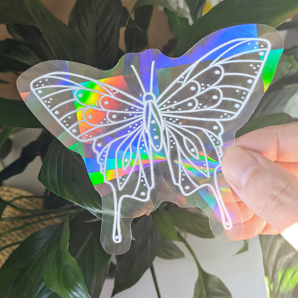 Holographic butterfly decal held in front of green leaves