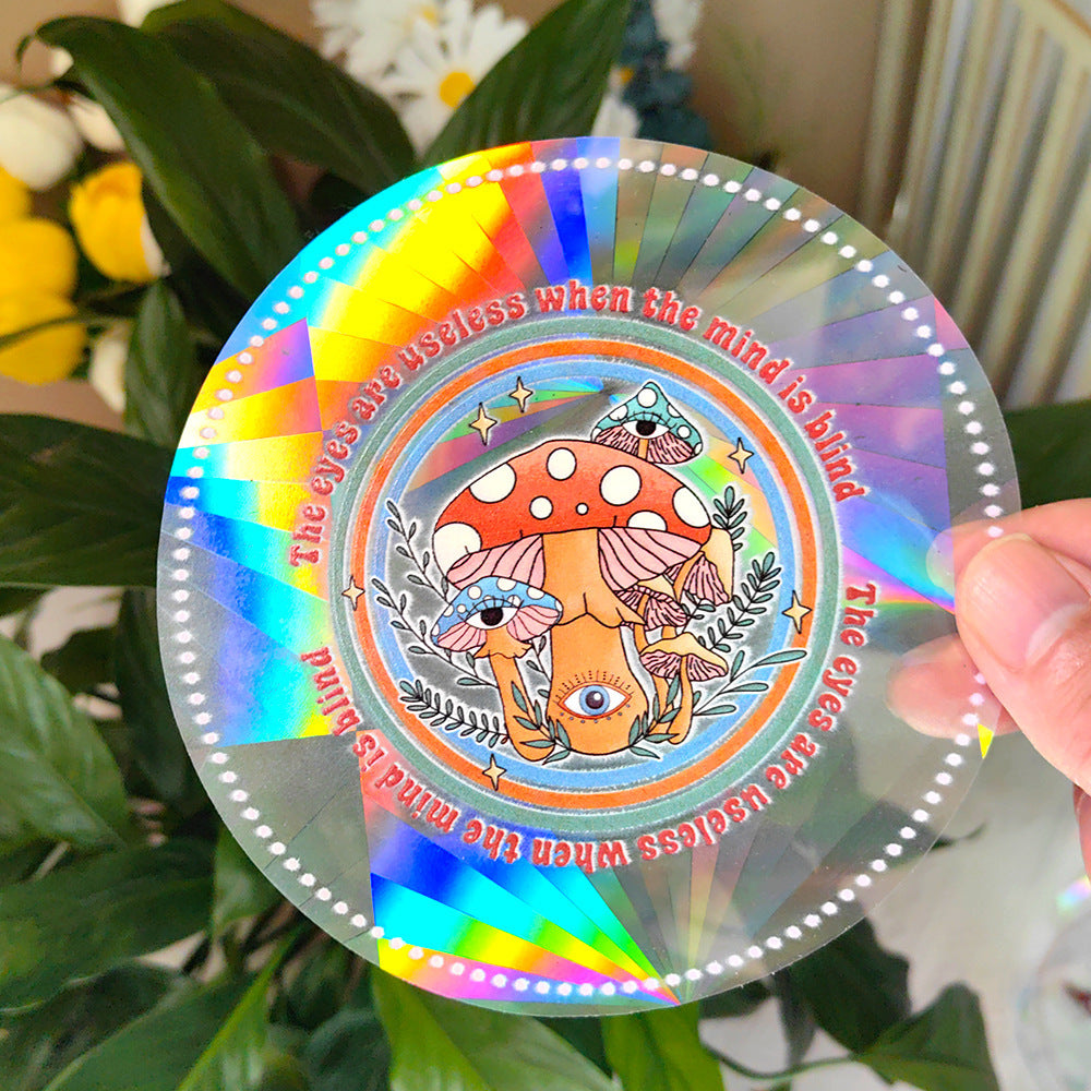 Colorful round sticker with psychedelic design held in front of green leaves