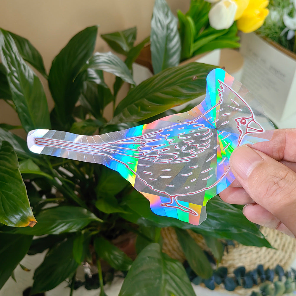 Holographic bird-shaped object held by a hand with plants in the background
