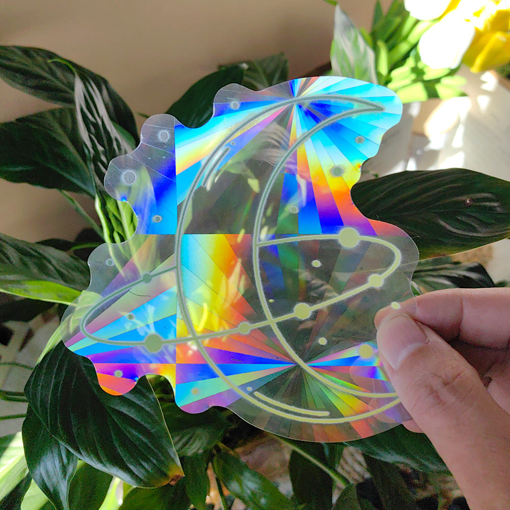 Holographic butterfly-shaped object held in front of green leaves