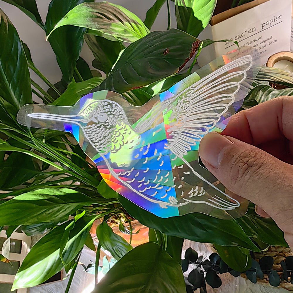 Holographic hummingbird decal held over a plant