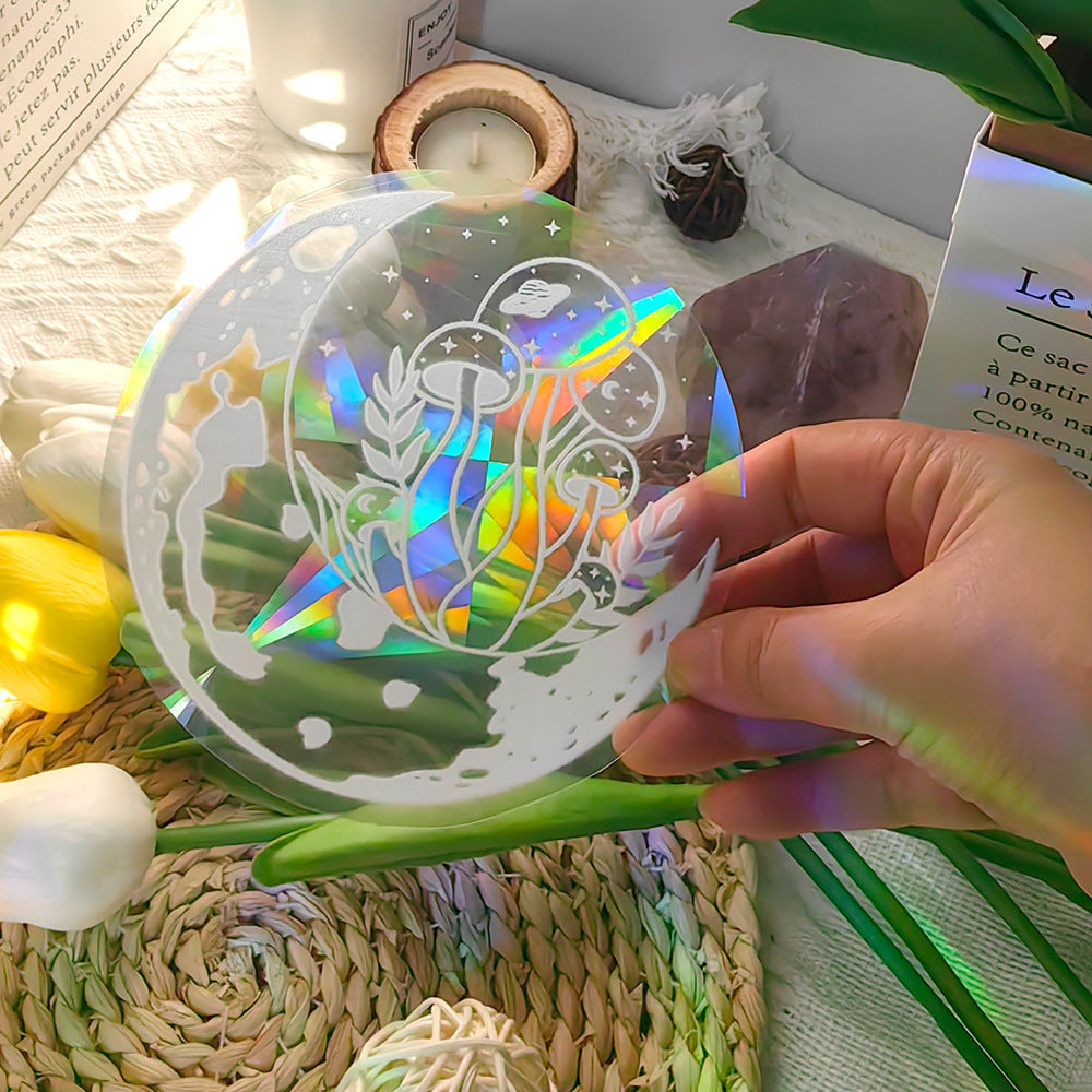 Hand holding a transparent decorative item with unicorn design on a soft surface with flowers and books.