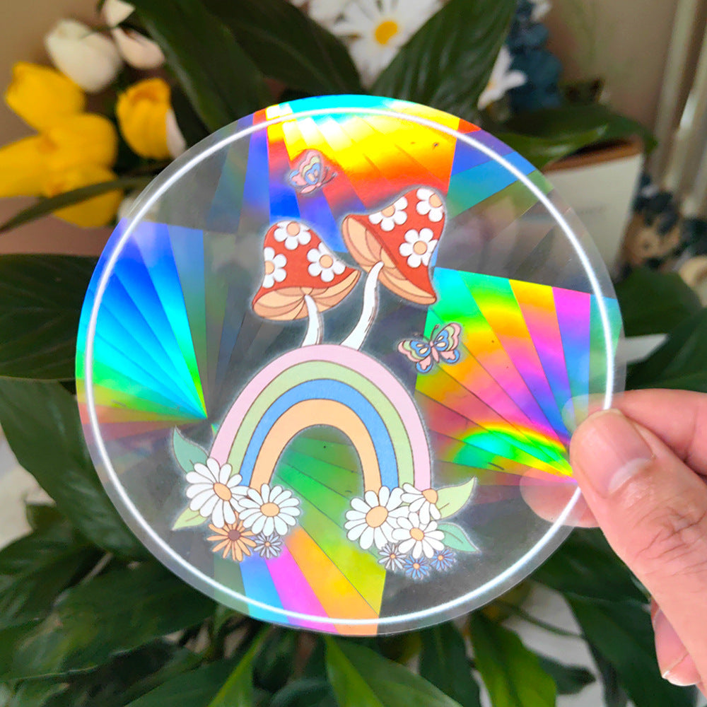 Holographic disc with rainbow, mushrooms, and flowers held in front of green leaves.
