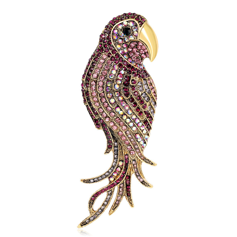 Jeweled parrot brooch with pink and gold details on a white background