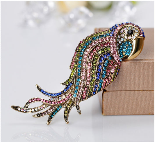 Colorful parrot-shaped brooch with gemstones on a light background