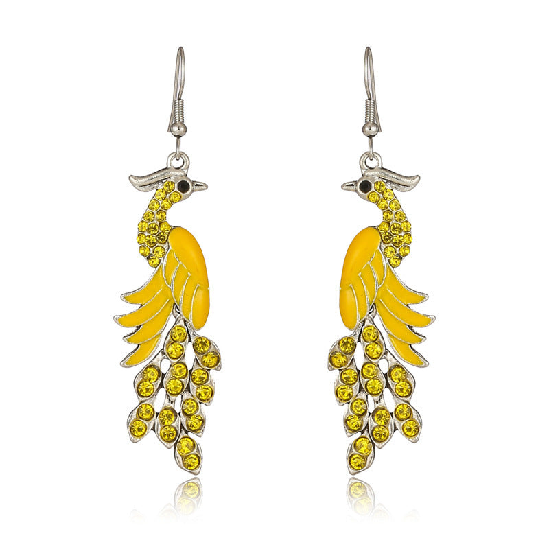 Pair of yellow feather-shaped earrings on a white background