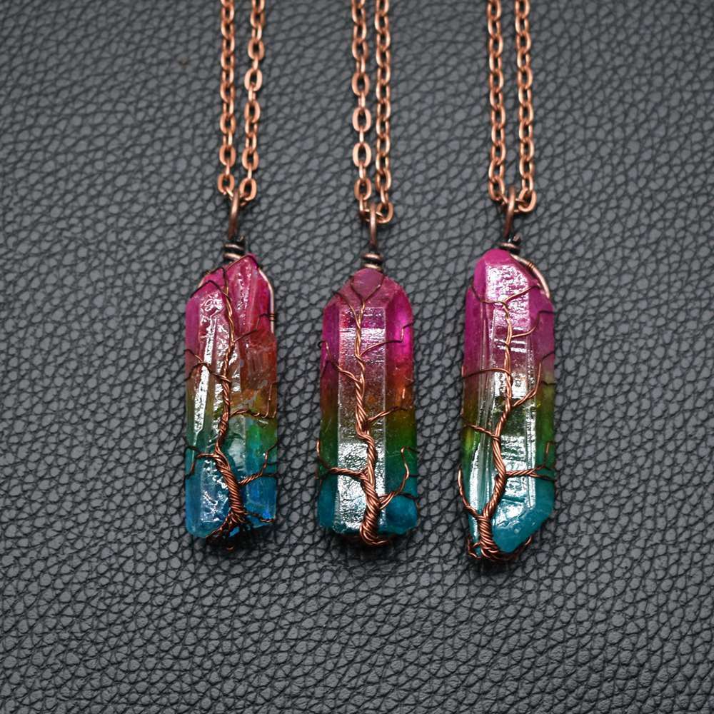 Three crystal necklaces with colorful stones on a textured gray background