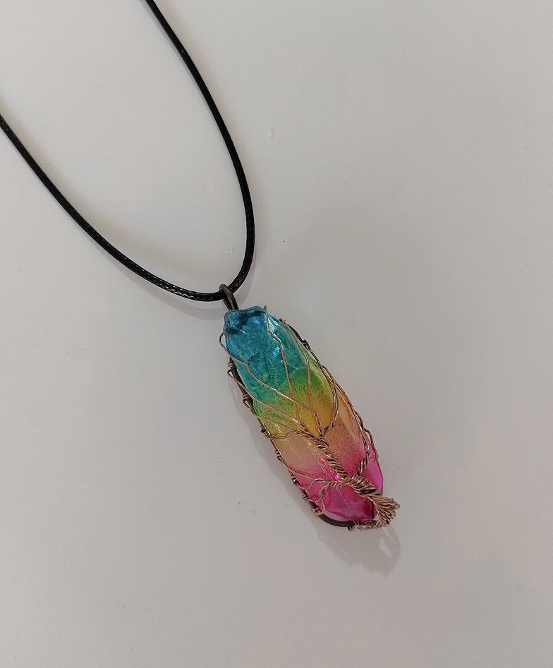 Multicolored pendant on a black cord against a white background