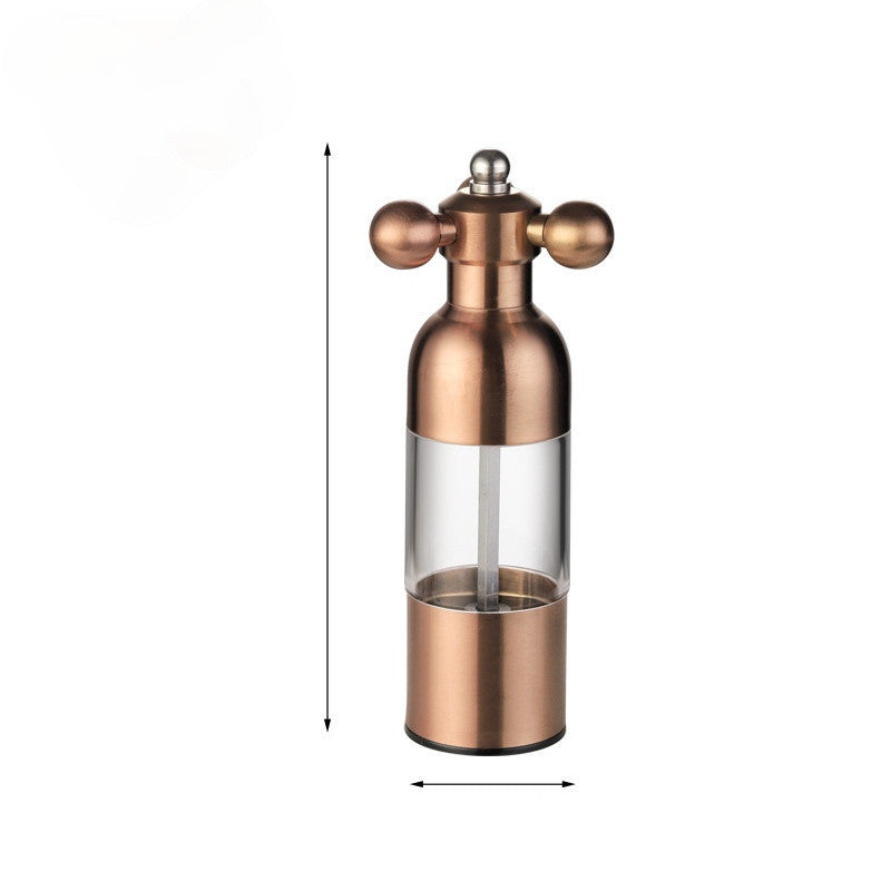 Copper pepper grinder with clear glass body on a white background