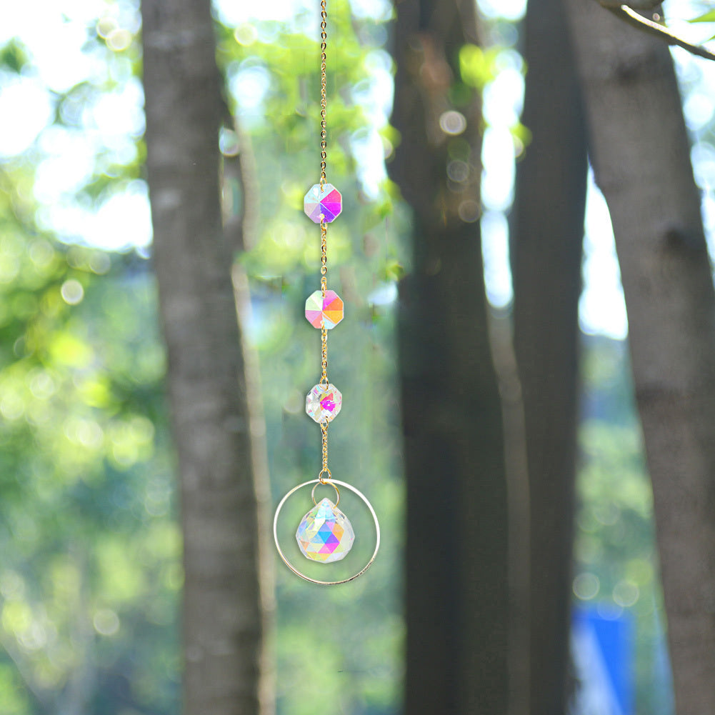 Decorative rainbow crystal hanging against a blurred natural background
