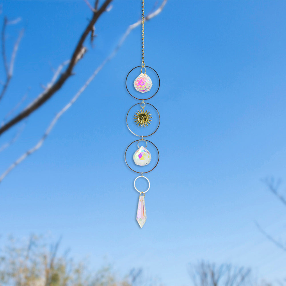 Decorative hanging crystal with colorful stones against a blue sky