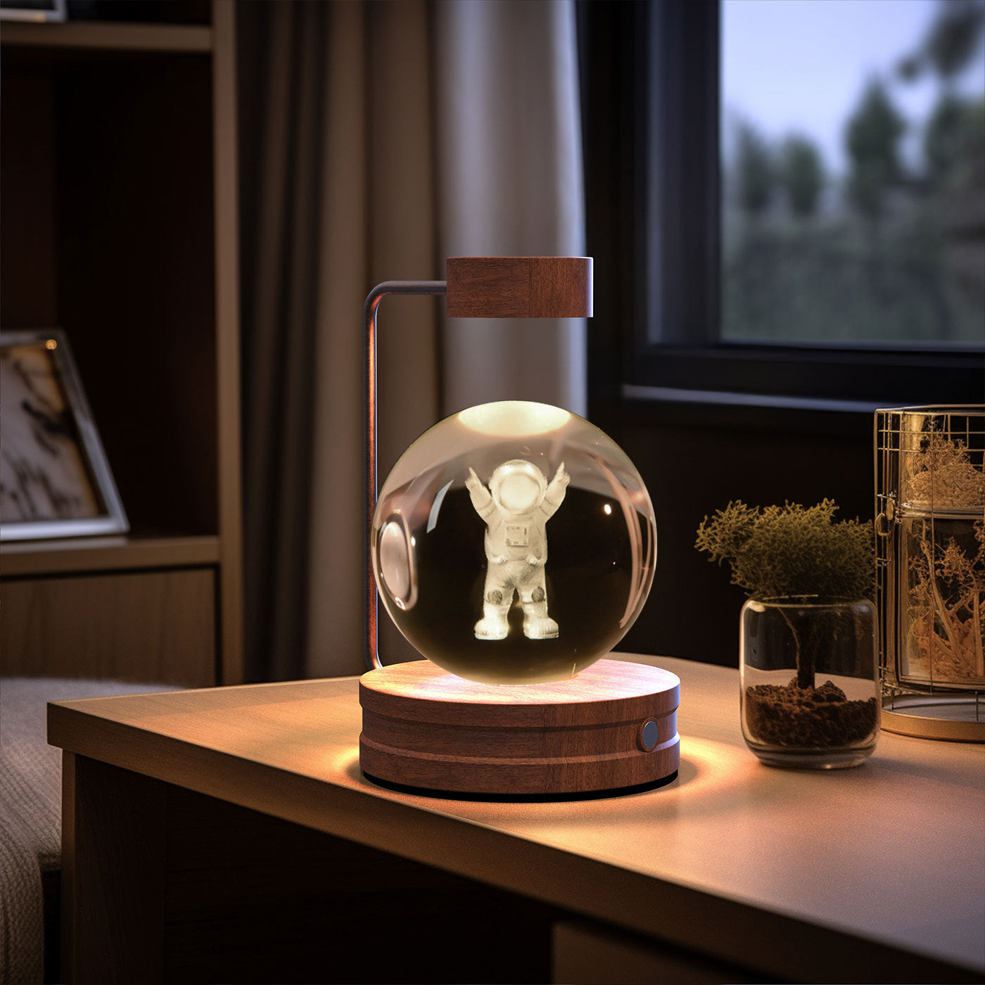 Decorative lamp with a transparent sphere containing an astronaut figure on a wooden base, placed on a table.