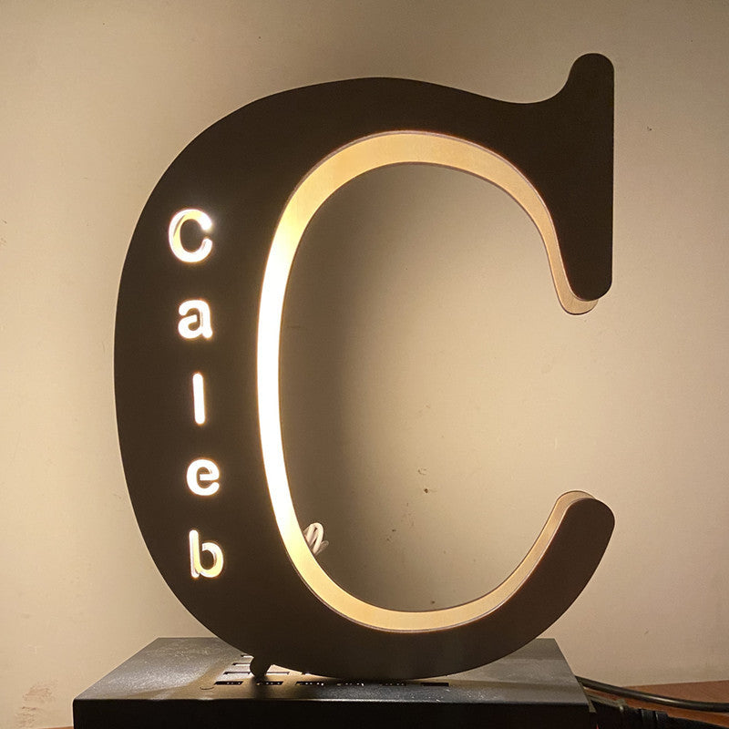 Decorative letter 'C' with 'Caleb' inside, illuminated against a neutral background
