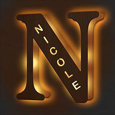Decorative letter 'N' with the name 'Nicole' inside, illuminated with a warm glow.