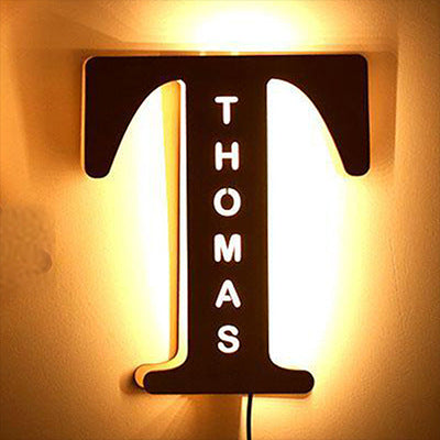 Decorative letter 'T' with 'THOMAS' on a warm-toned background