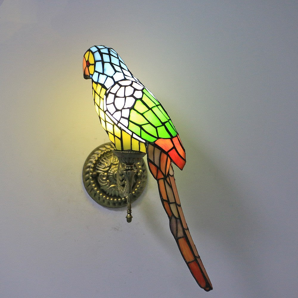 Stained glass wall light shaped like a parrot on a plain background