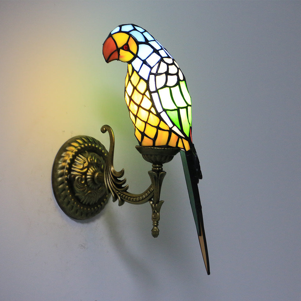 Stained glass parrot wall light fixture on a plain background
