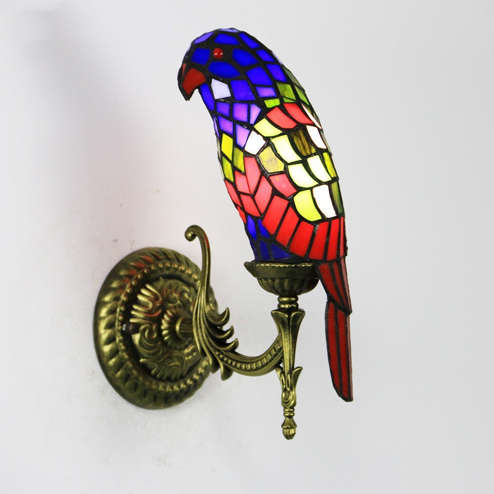 Colorful parrot-shaped wall light fixture on a white background