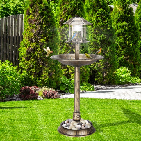 Bird feeder and birdbath with birds on a grassy lawn
