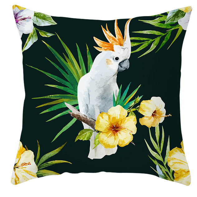 Decorative pillow with a parrot and tropical flowers design on a dark green background