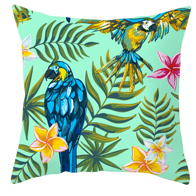 Decorative pillow with parrot and tropical leaf pattern on a light blue background