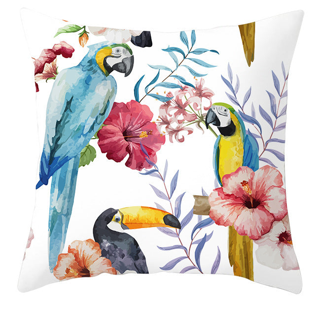Decorative pillow with parrot, toucan, and floral design on a white background