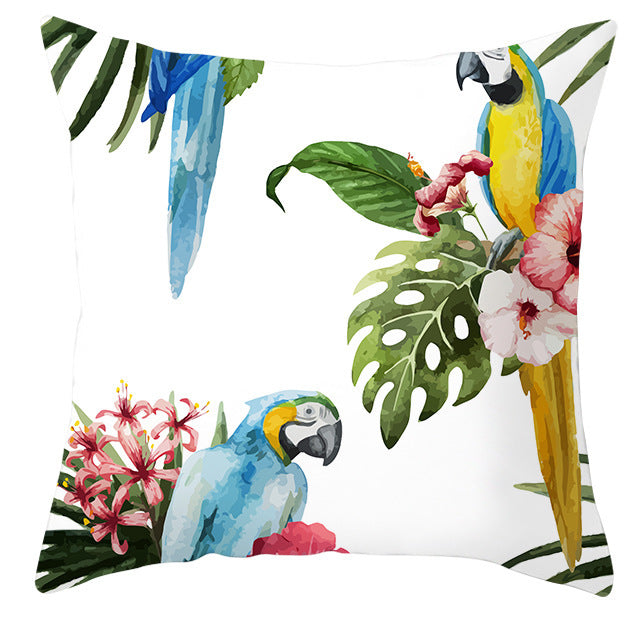 Decorative pillow with parrot and tropical leaf design on a white background